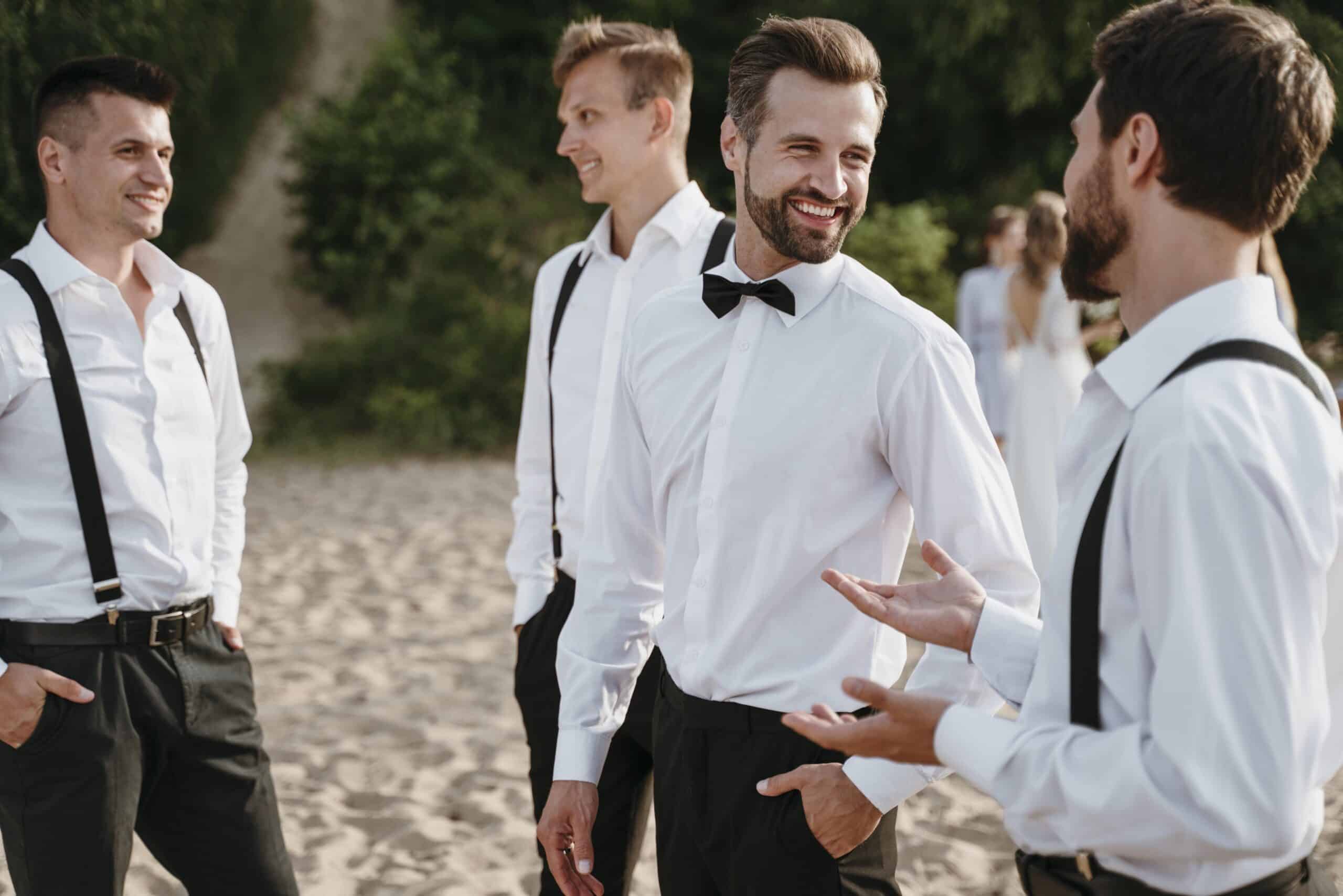 groom best men posing beach scaled