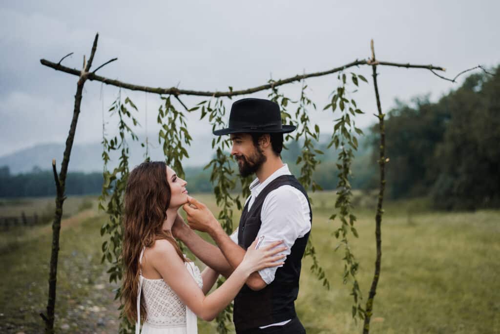side view romantic couple holding hands while standing field against sky